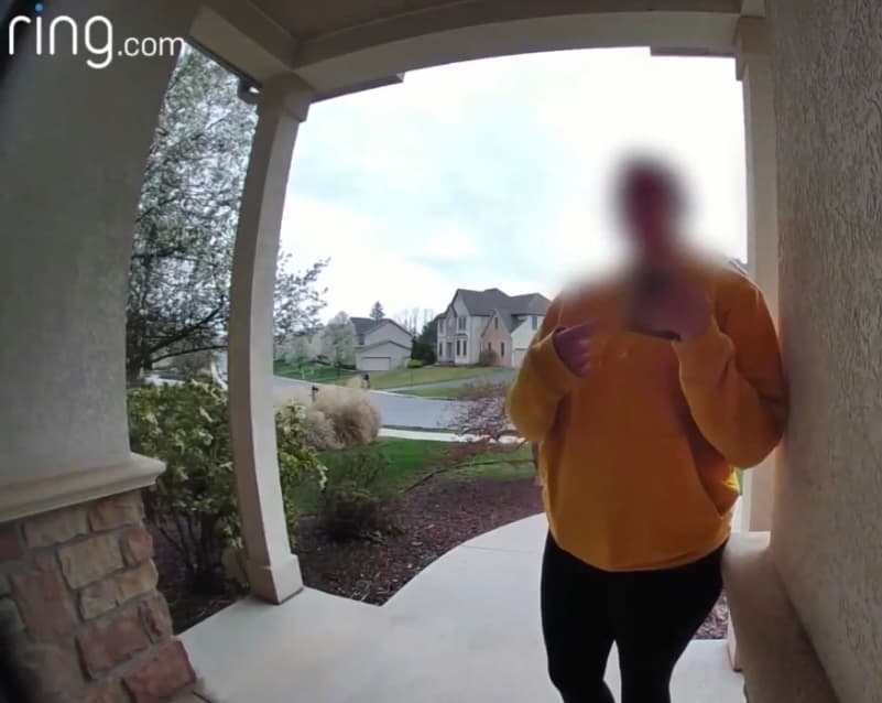 A Ring doorbell still of the woman returning the wallet, her face blurred out the way it first aired on the news
